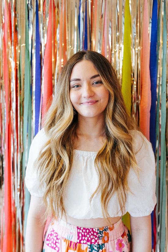 Nimki founder Emily with a colourful backdrop behind her in-store