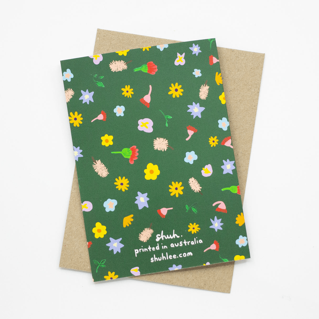 Meadow Greeting Card Colourful Christmas Shuh Lee: Shuh Lee Meadow Card: A forest green background with tiny objects from nature scattered across including bottlebrushes, yellow daisies, soft pink native flowers and small leaves.