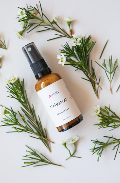 Celestial Aromatherapy Room Spray surrounded by flowers & bright green stems