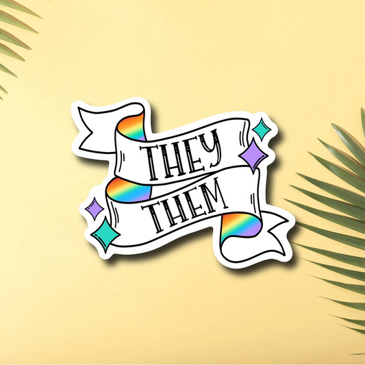 A bright and colorful vinyl sticker featuring they/them pronouns, shaped like a flag with rainbow corners and sparkles.