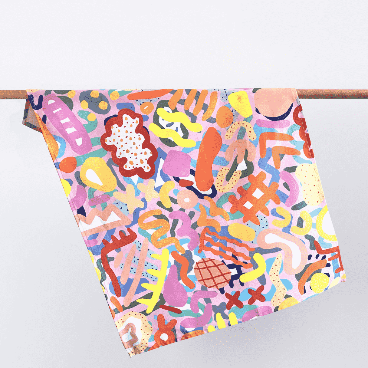 A colourful tea towel by Shuh Lee, it features a print emulating different shapes of coral in all different colours including yellow hues, bright orange, deep red and soft pastel pink.  