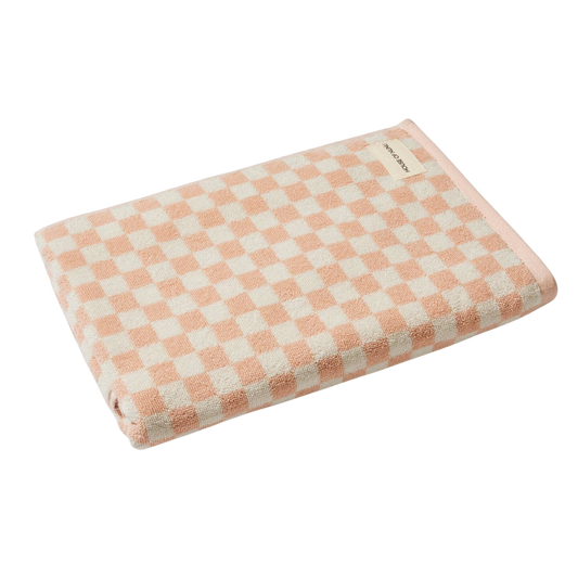 Bath towel in Pink Check by House of Nunu. This towel is white with soft peach checks and folded into a perfect rectangle. 