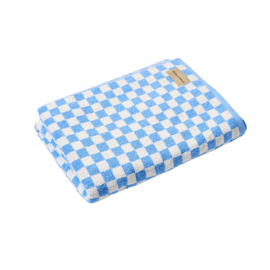 A super cute bath towel by House of Nunu: It's folded into a neat rectangle with a white base colour and light blue checks. 