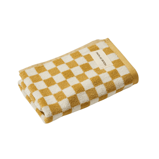 A mustard yellow and white check hand towel by house of Nunu. 