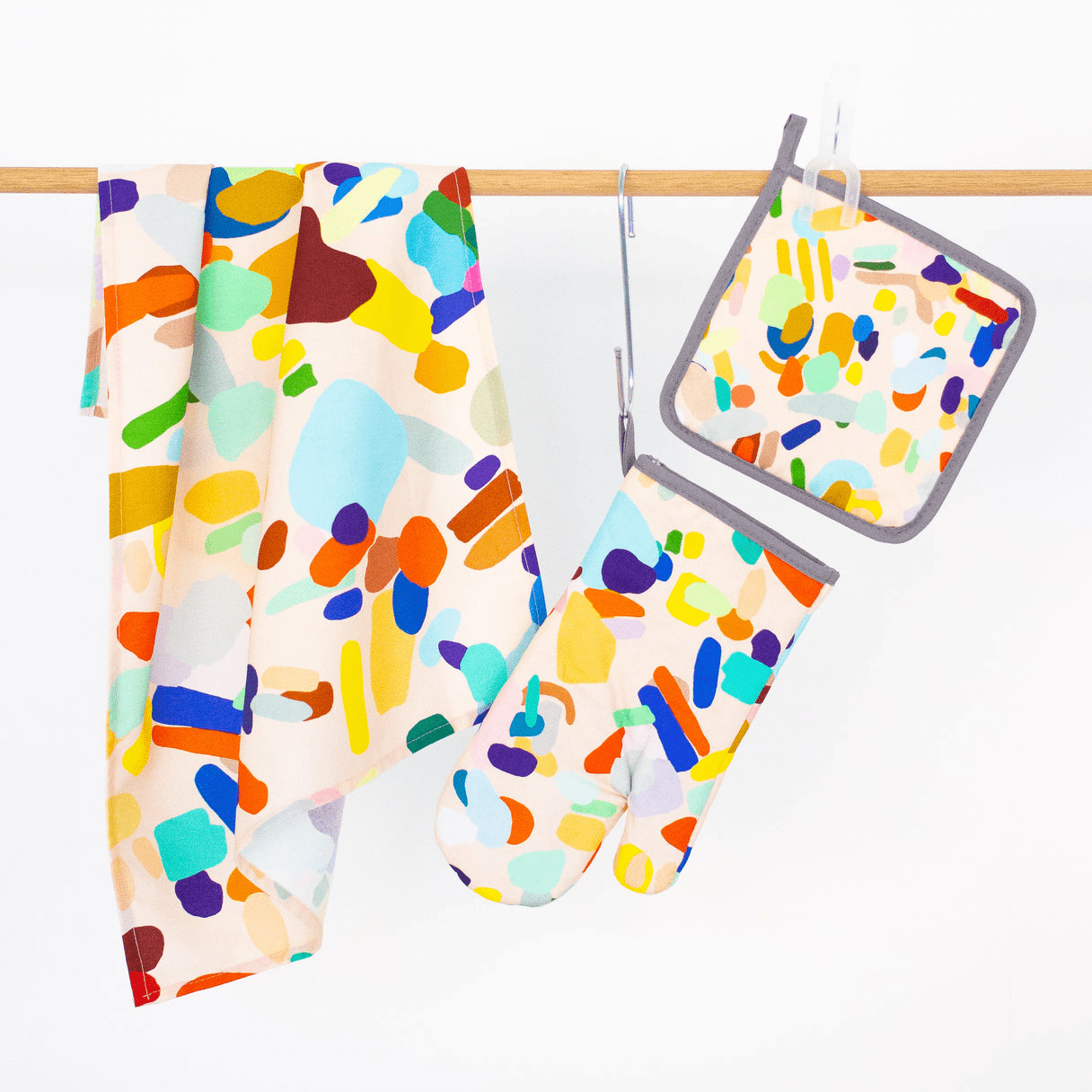 Shuh's Hanging Out Oven Mitt: A cream background with colourful abstract, pastel shapes across the print. 