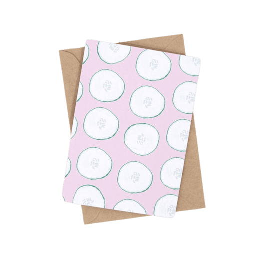 Shuh Lee Cool as a Cucumber Greeting Card. This card has a pastel pink background with green cut outs of cucumbers across the front. 