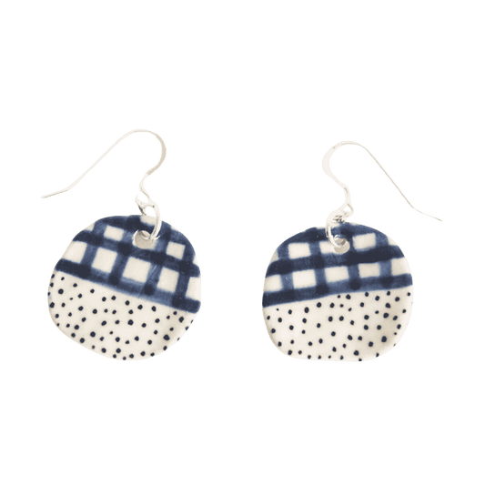 Shuh Lee 'Halfy' Earrings. They have a neat hook at the top and a ceramic, circle attached adorned with half a blue patchwork pattern and underneath black speckles. 