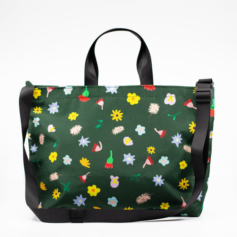Shuh Lee's vibrant handbag with shoulder strap: A joyful design with a forest green background and tiny pieces of nature scattered across including bottle brushes, daisies, leaves and other Australian fauna. 