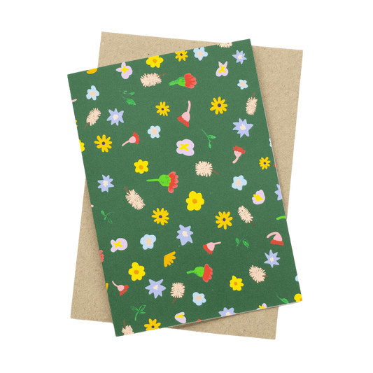 Shuh Lee Meadow Card: A forest green background with tiny objects from nature scattered across including bottlebrushes, yellow daisies, soft pink native flowers and small leaves. 